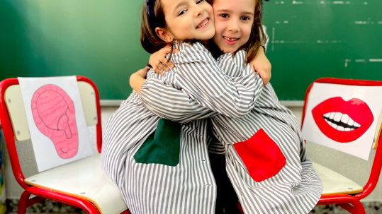 Dos alumnas abrazándose tras resolver un conflicto en el rincón boca oreja.