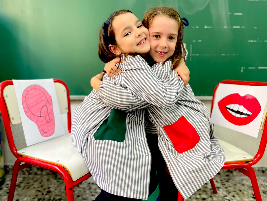 Dos alumnas abrazándose tras resolver un conflicto en el rincón boca oreja.